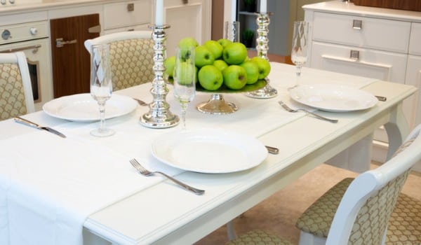 How can I incorporate table linens into my kitchen table decor?