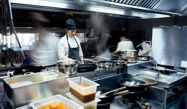 Why do chefs in modern kitchens undergo cross-training to work on multiple stations